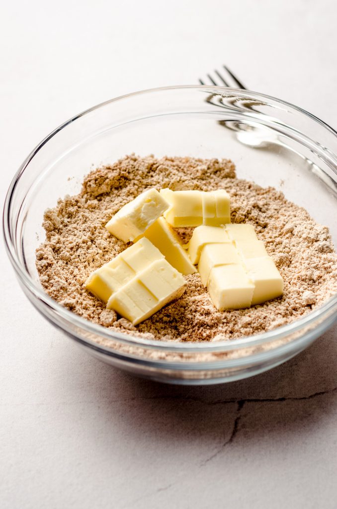 chunked butter in a bowl of streusel topping ingredients