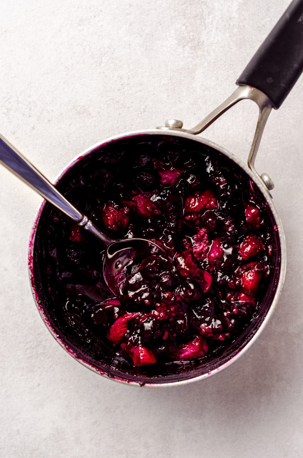 A simmered and thickened berry compote in a saucepan.