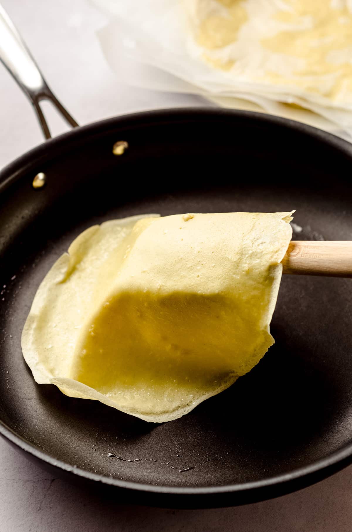 Sliding a crepe out of a nonstick skillet.