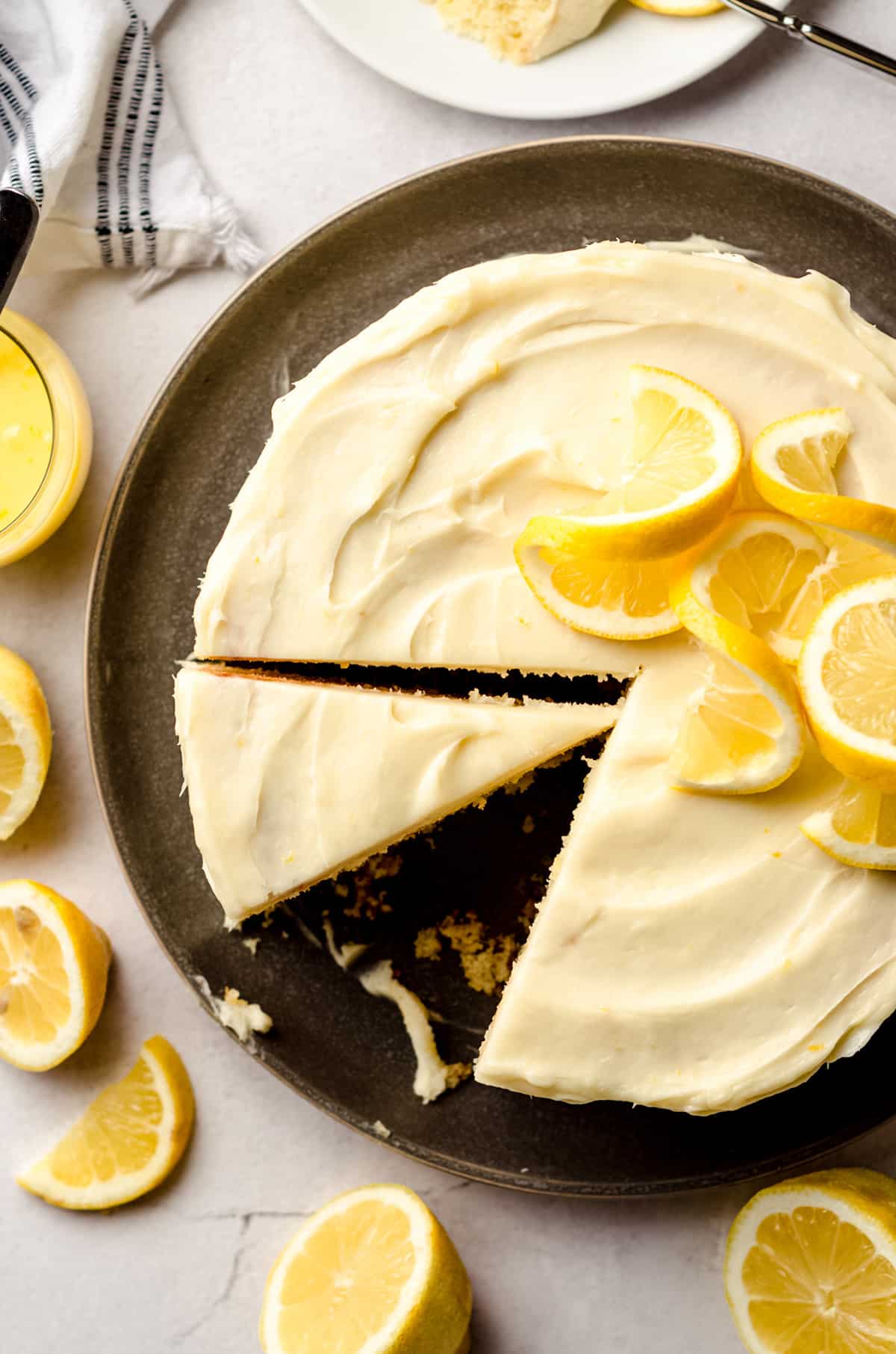 A lemon cake, cut into slices and topped with lemon slices.
