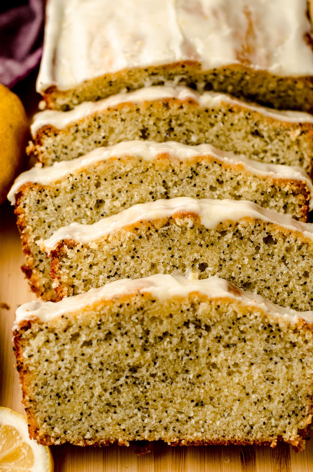 Several slices of lemon poppy seed bread fanned on top of a cutting board.