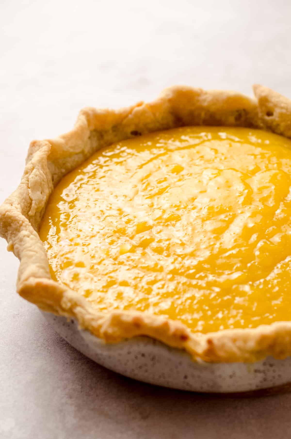 A pie crust that has been filled with a homemade lemon curd.