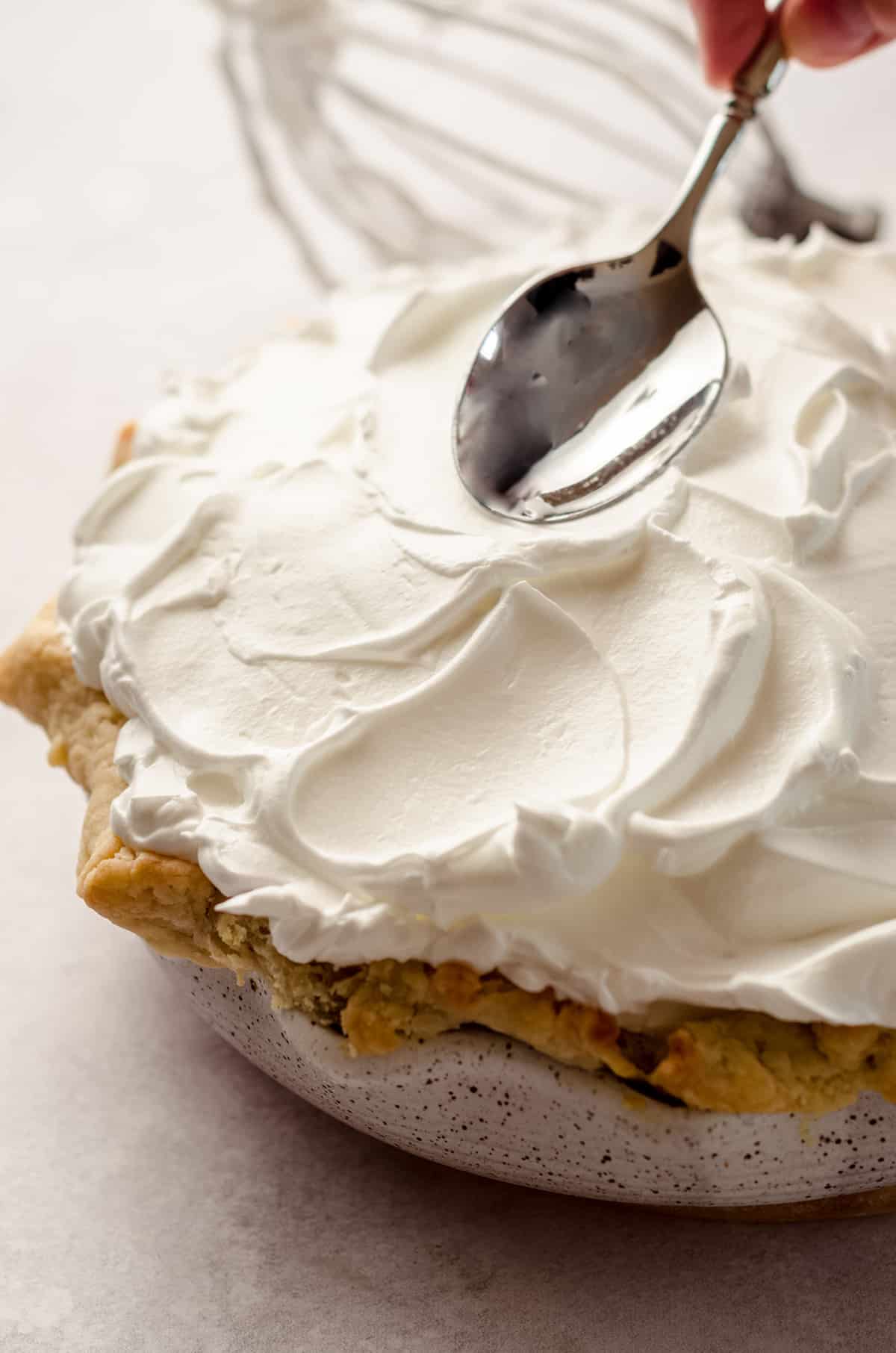 Using a spoon to create dramatic peaks for lemon meringue pie.
