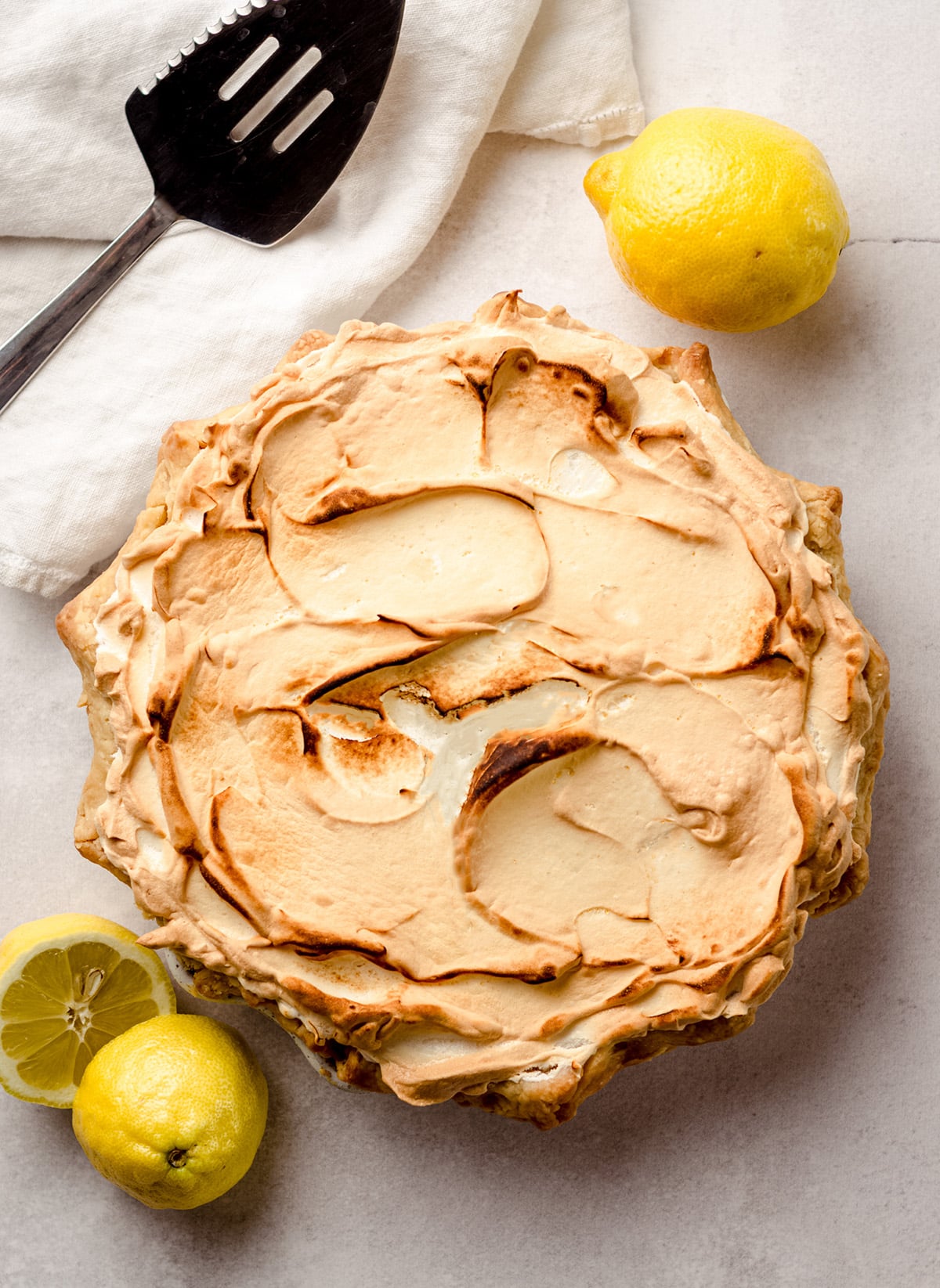 An overhead shot of a lemon meringue pie with browned meringue.