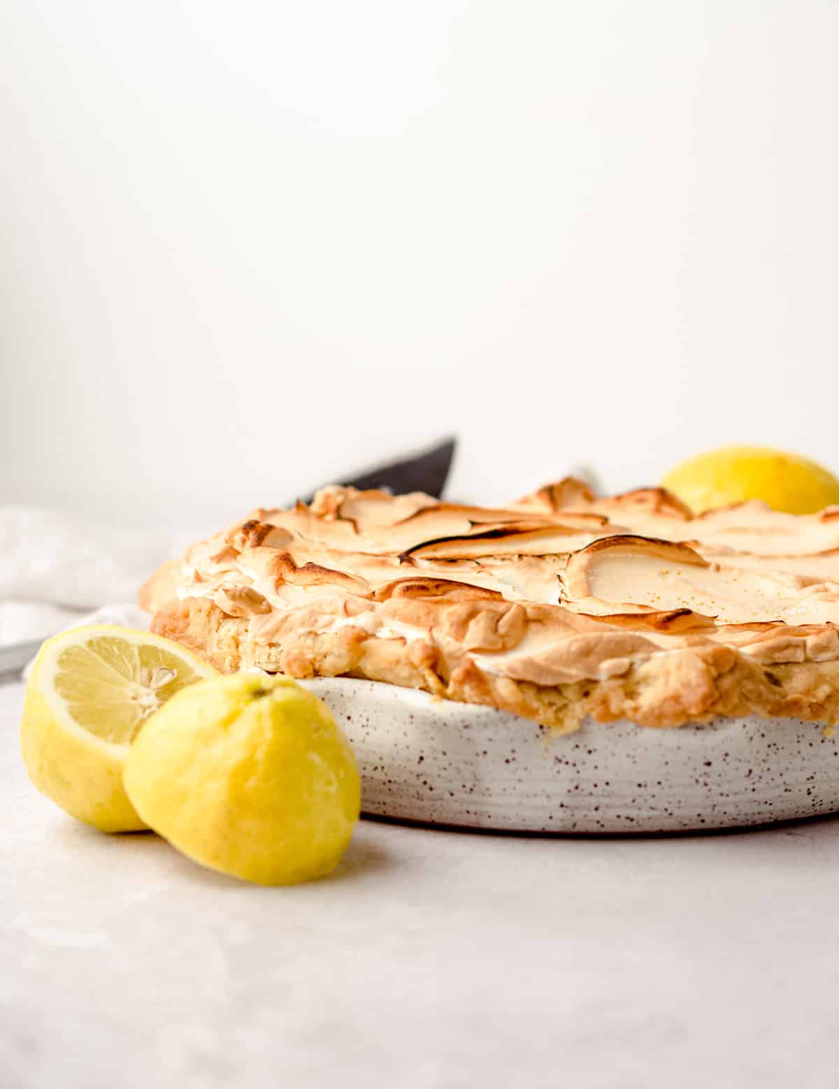 A side view of a lemon meringue pie with browned meringue.