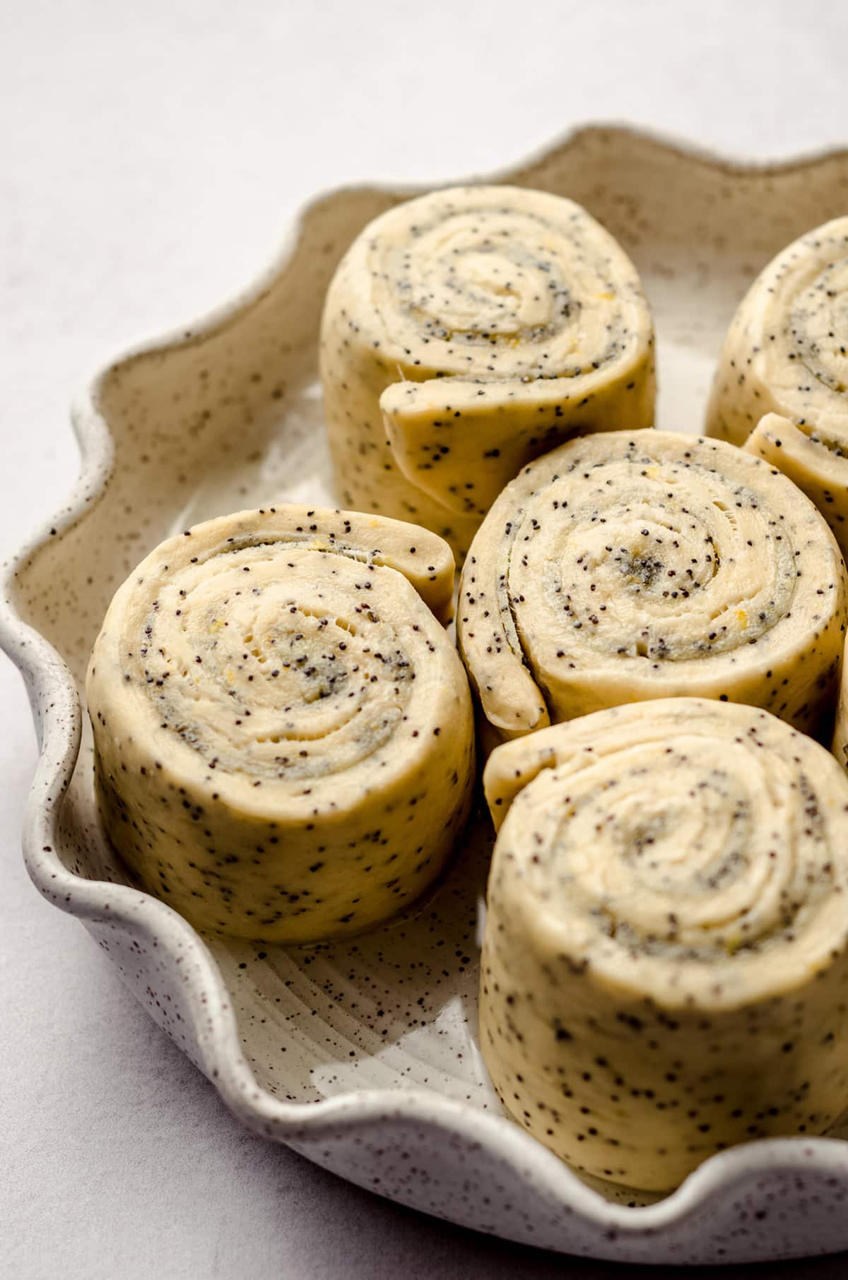 Sweet rolls with poppy seeds in a pie plate.