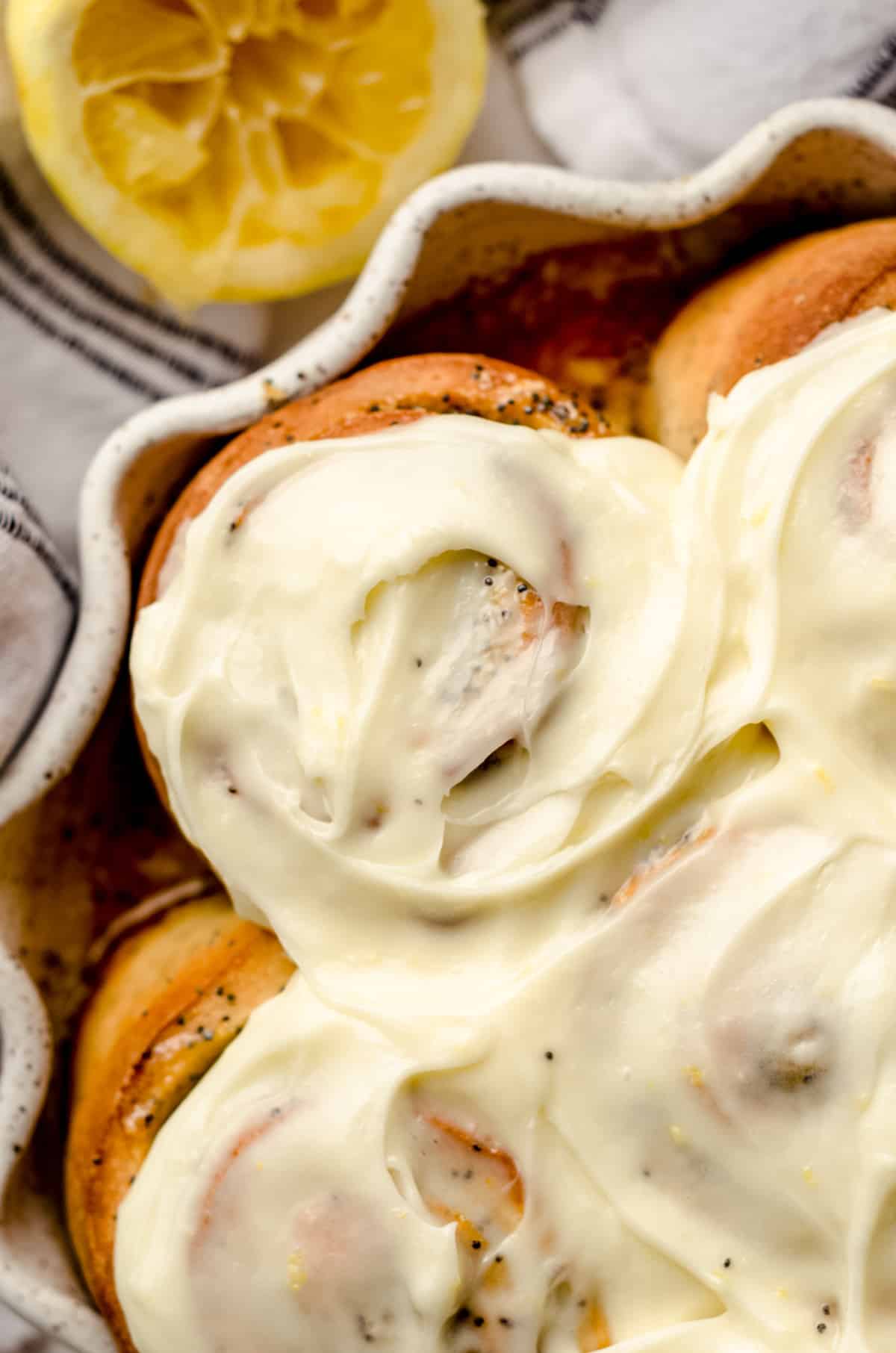 An overhead shot of lemon poppy seed rolls that have been covered in a cream cheese frosting.