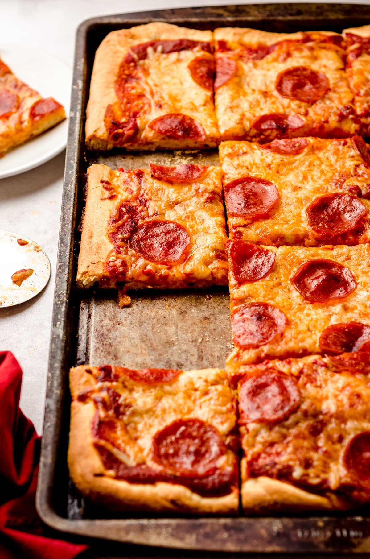 A rectangular homemade pizza, with several slices missing.