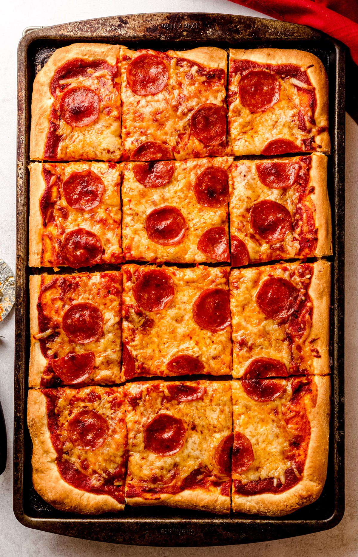 A large rectangular pizza, cut into square slices.