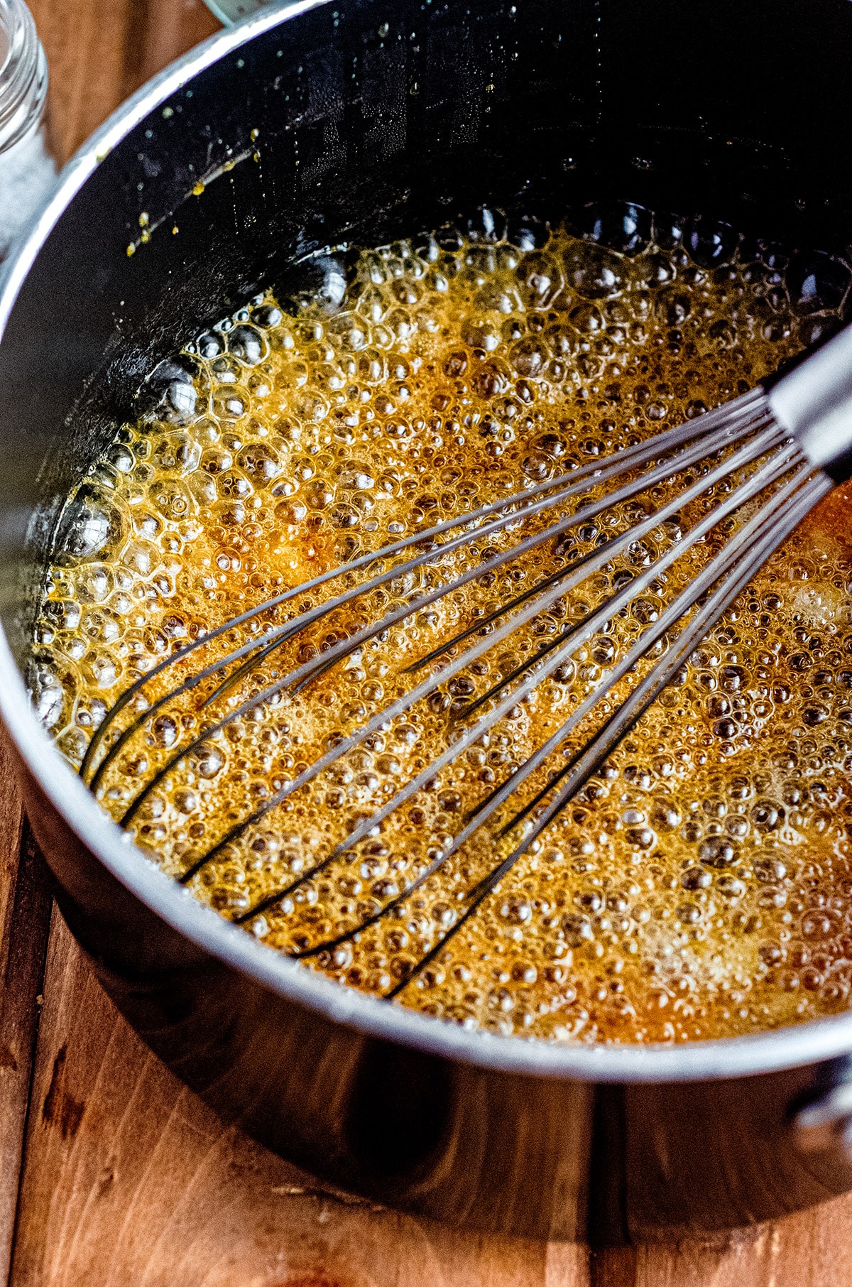 bubbly mixture of salted caramel sauce after adding the slices of butter