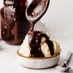 a spoon dripping homemade hot fudge sauce onto ice cream