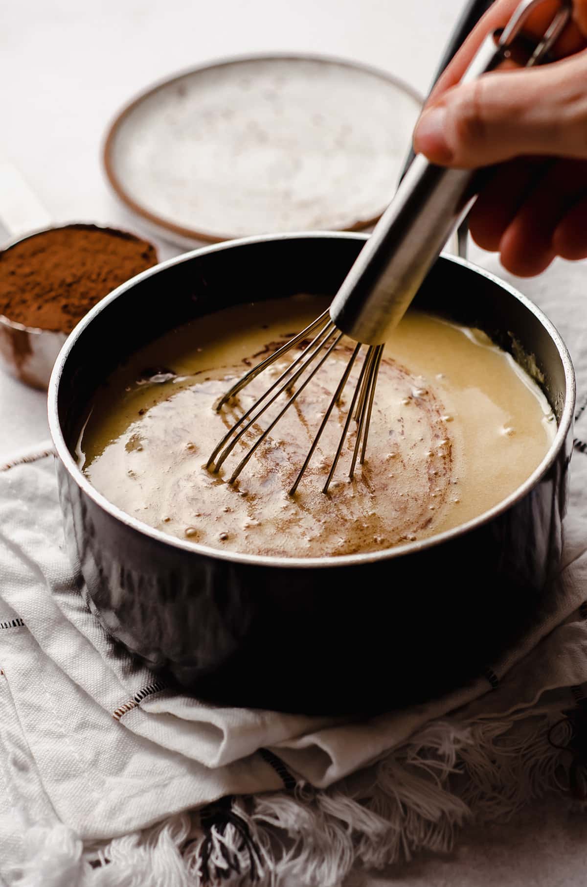 whisking ingredients together in a saucepan for homemade hot fudge sauce