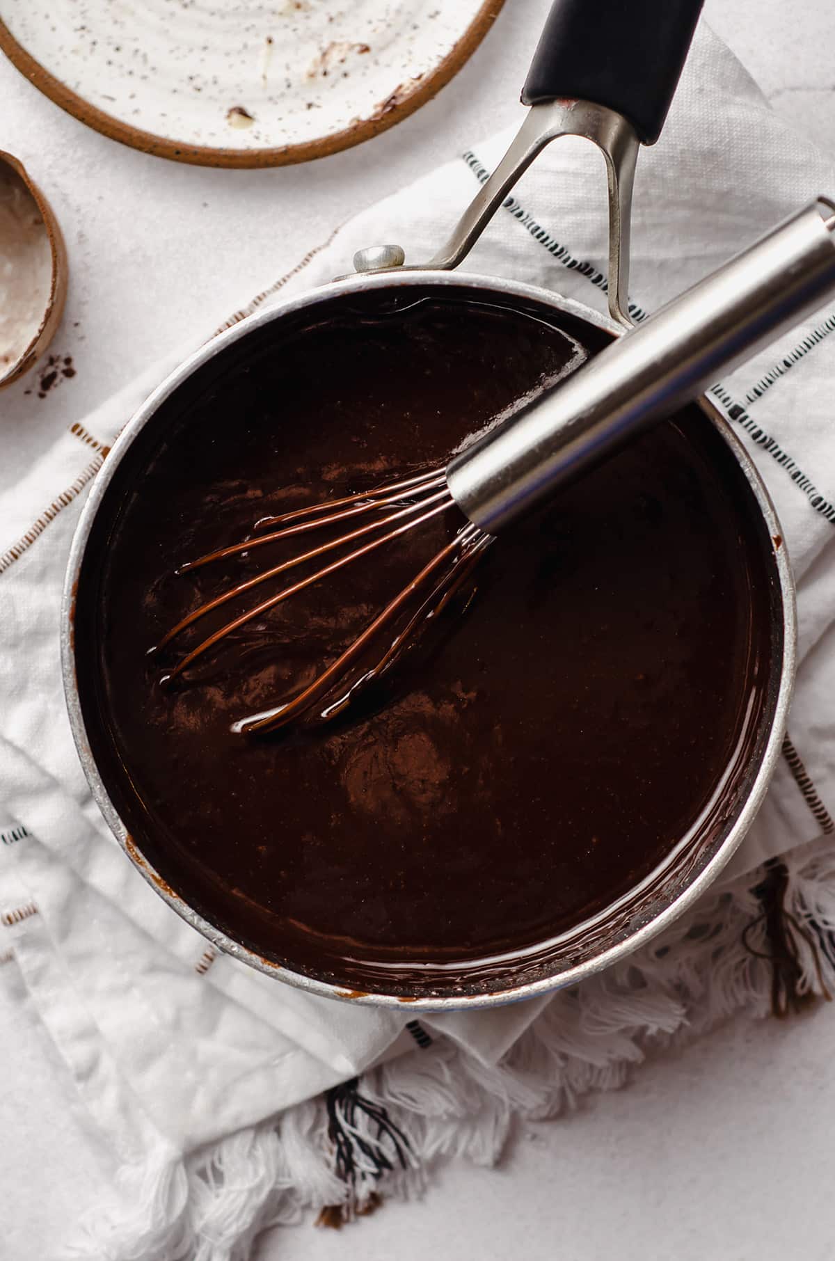 aerial photo of hot fudge in a saucepan with a whisk
