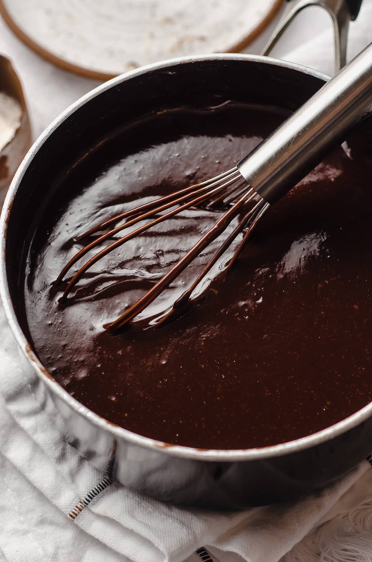 hot fudge in a saucepan with a whisk