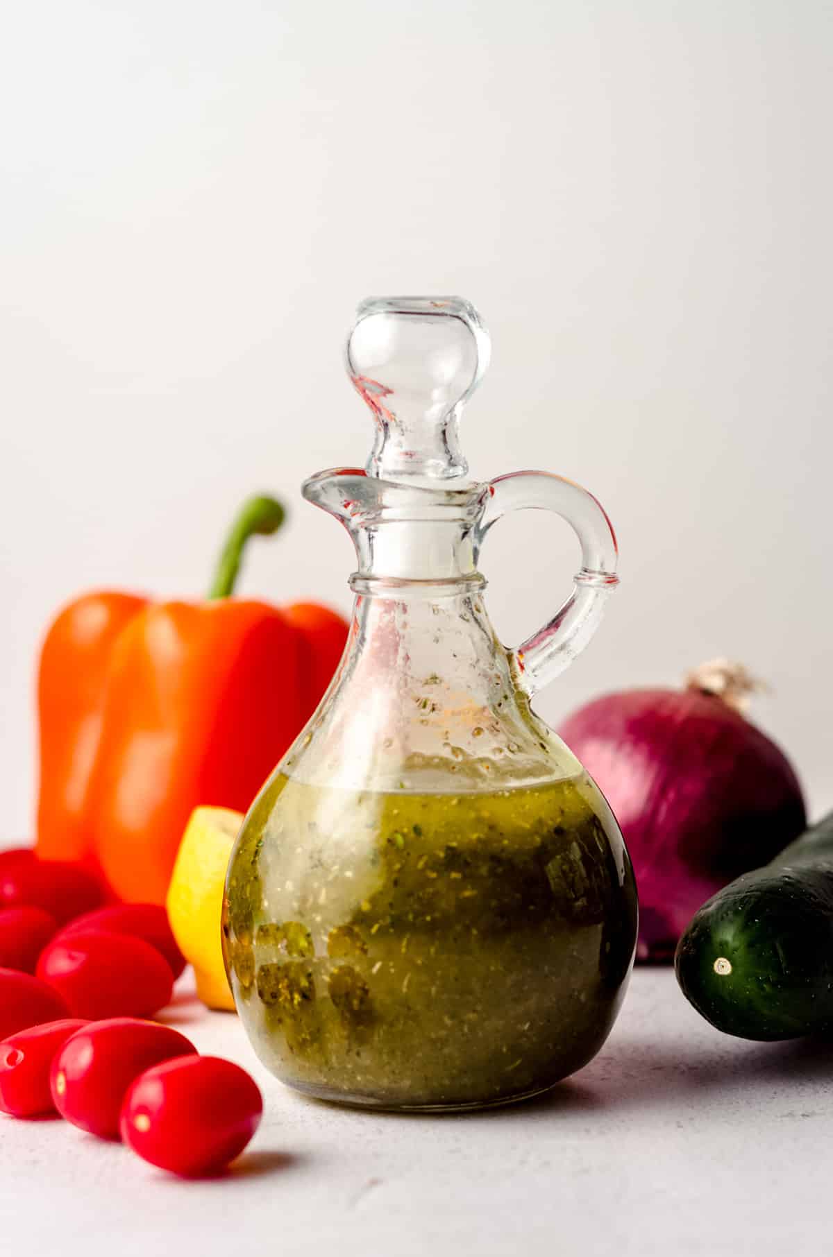 bottle of italian dressing with fresh veggies around it