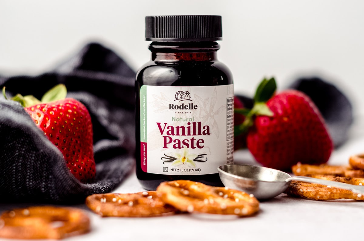 bottle of rodelle vanilla paste with strawberries and pretzels around it