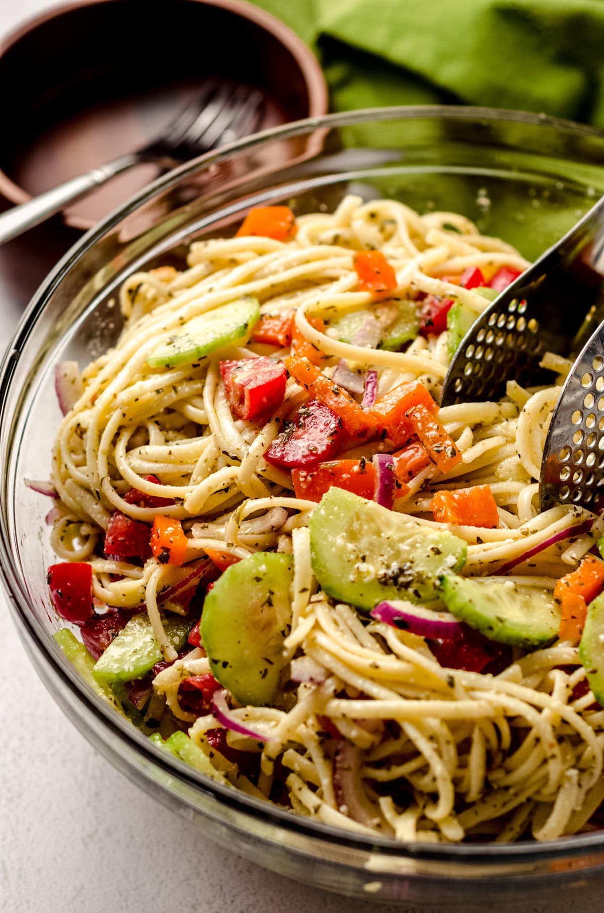 Tossing a cold pasta salad together with a pair of tongs.