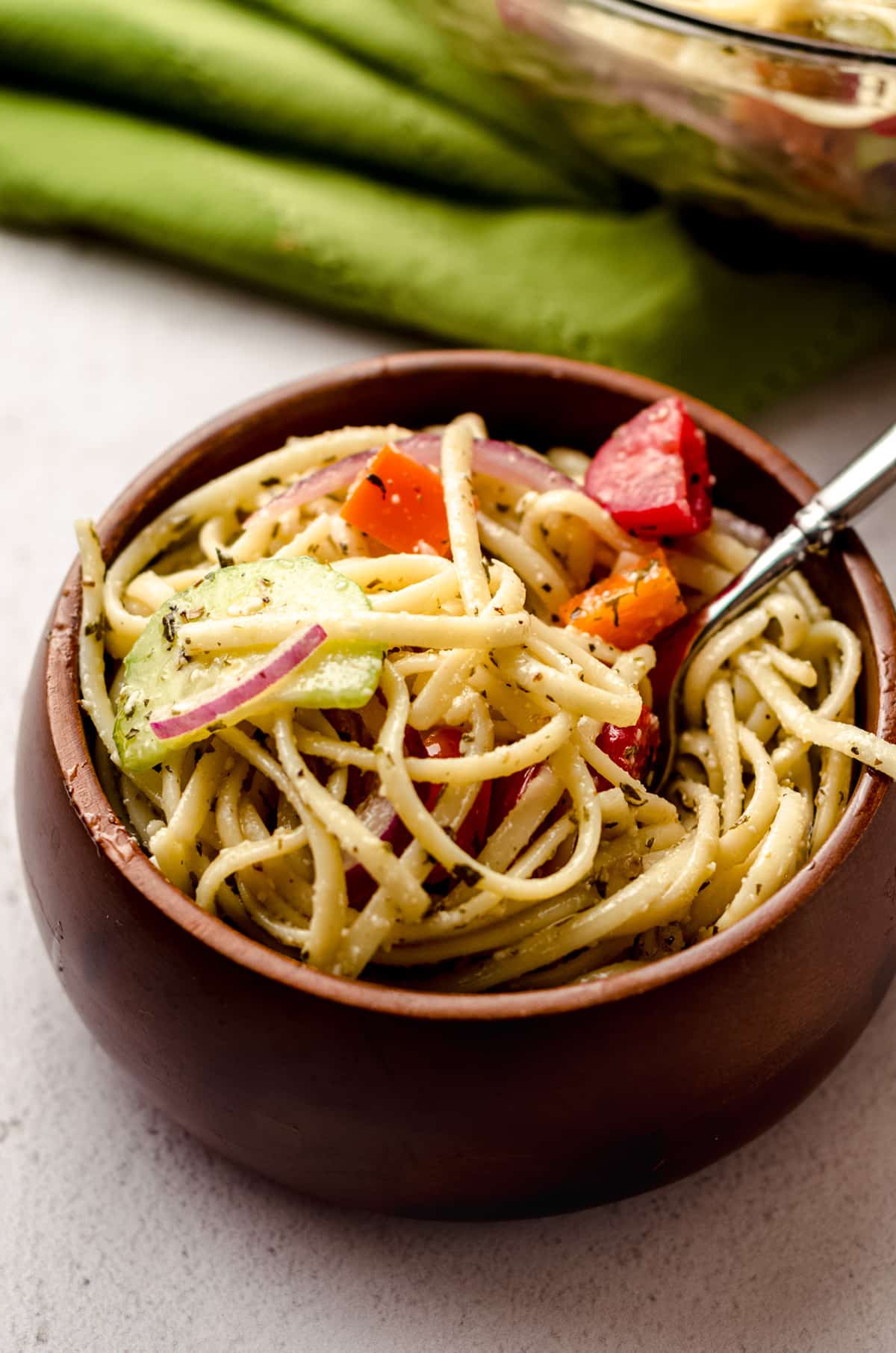 A small wooden bowl filled with a spaghetti salad.