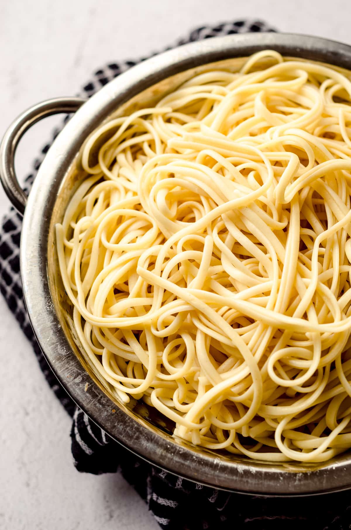 Spaghetti noodles draining in a colander.