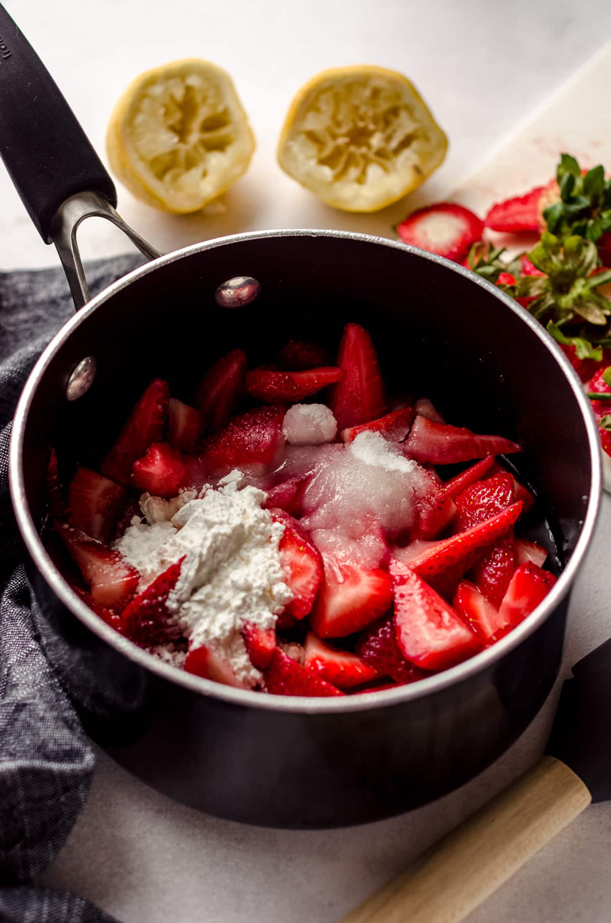 ingredients to make strawberry compote in a saucepan