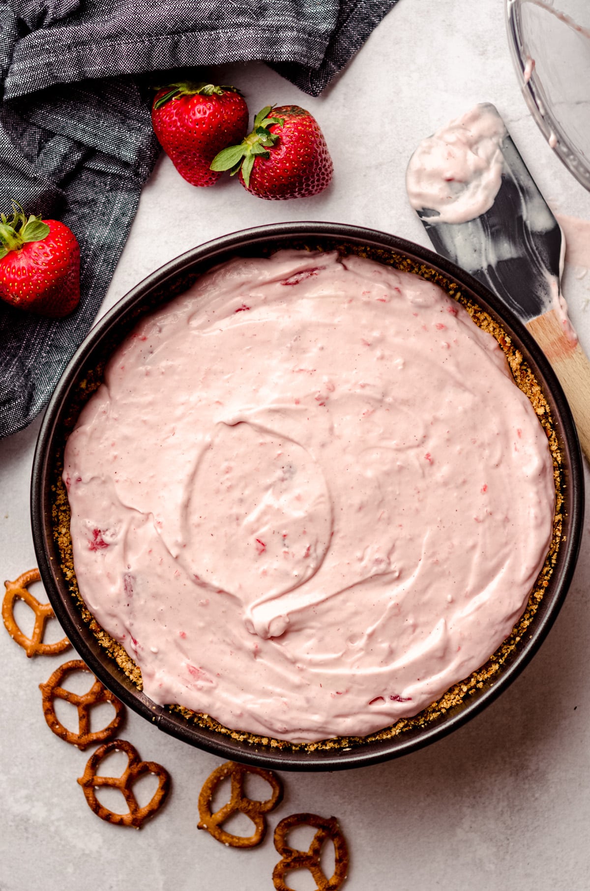 aerial photo of strawberry pretzel pie in a springform pan ready to chill