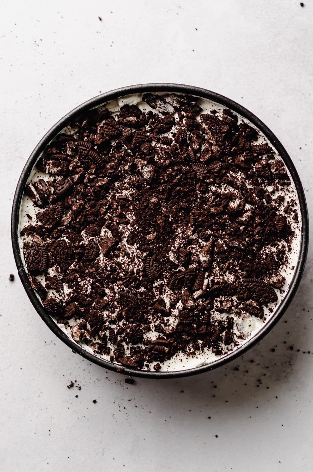An overhead view of an ice cream cake topped with Oreo cookies.