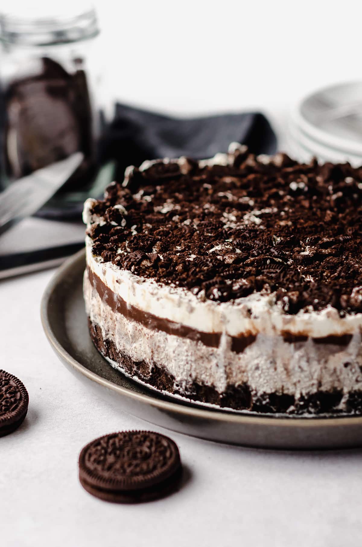 An ice cream cake with multiple layers and topped with Oreo cookies.