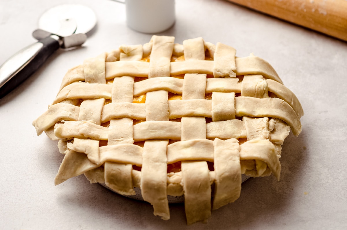A pie with a lattice crust, and some overhang on the edges.