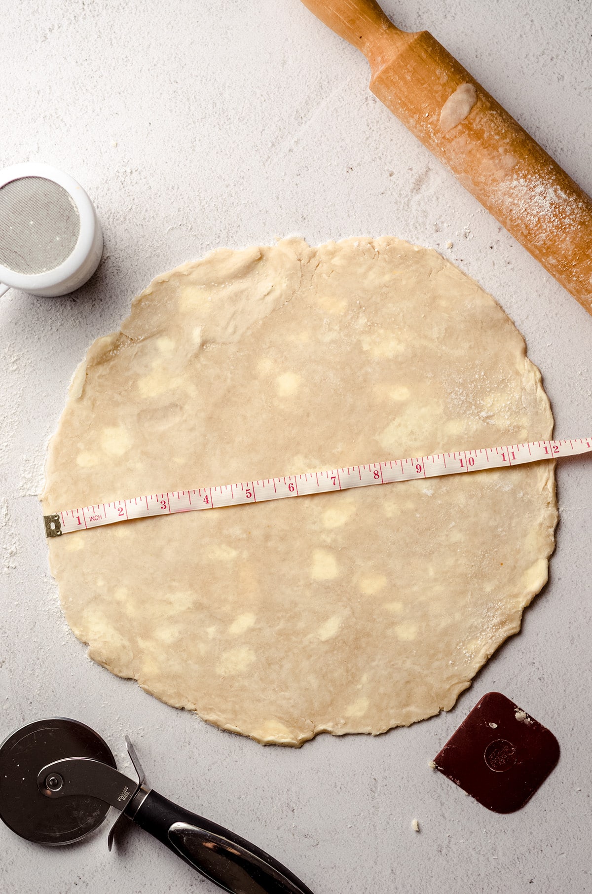 Measuring a round of pie dough.
