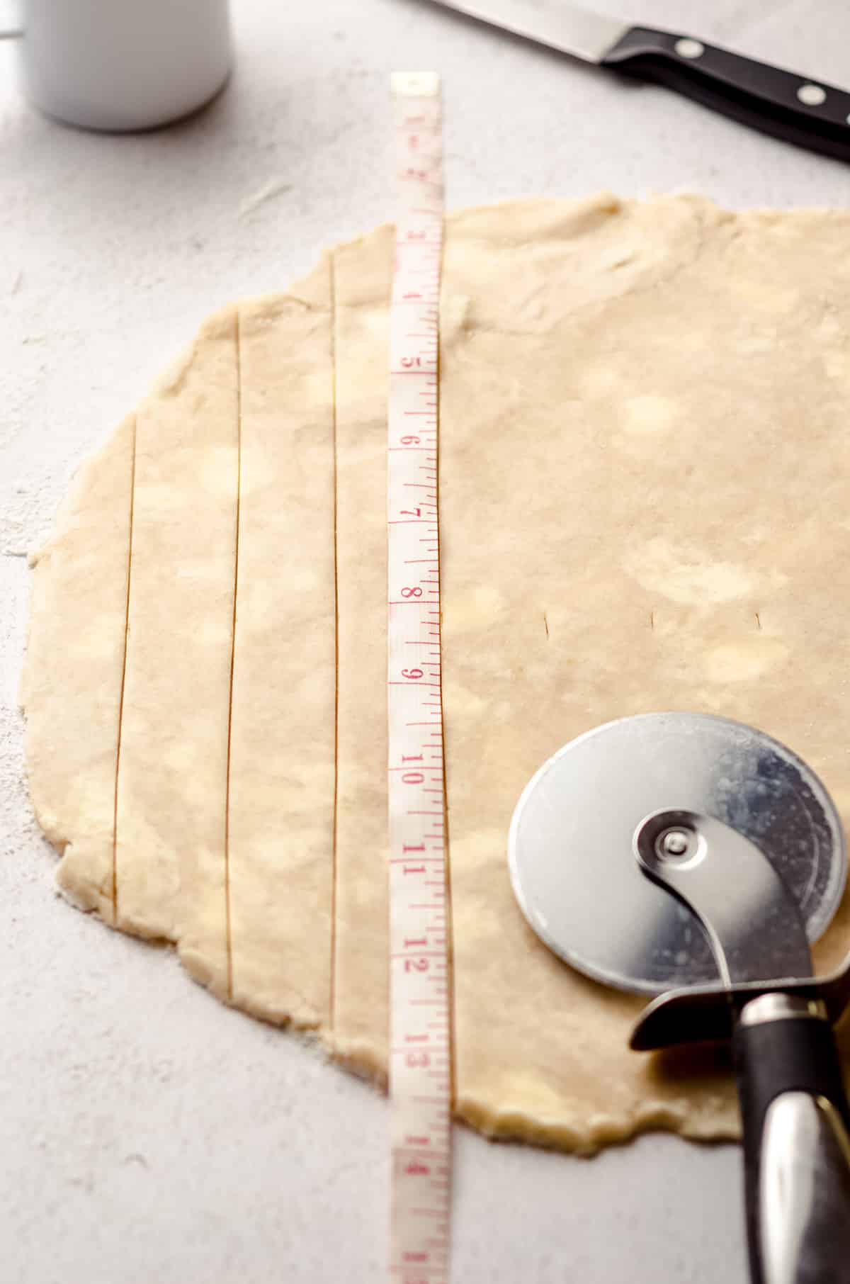 Measuring strips of pie dough for a lattice crust.