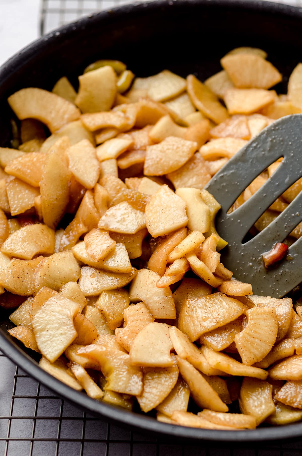 caramelized apples in a saucepan with a spatula