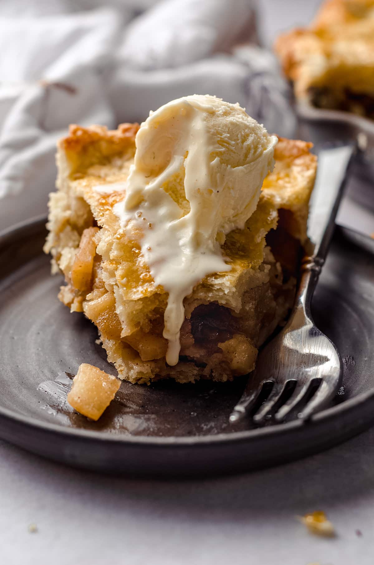 apple pie with a bite taken out of it and ice cream dripping down the front