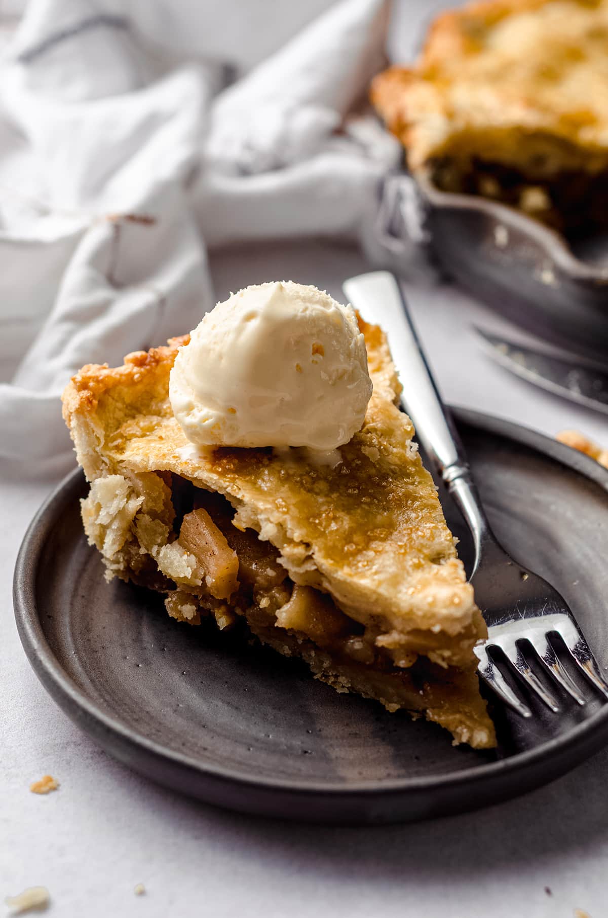 slice of apple pie on a plate with a scoop of ice cream on top