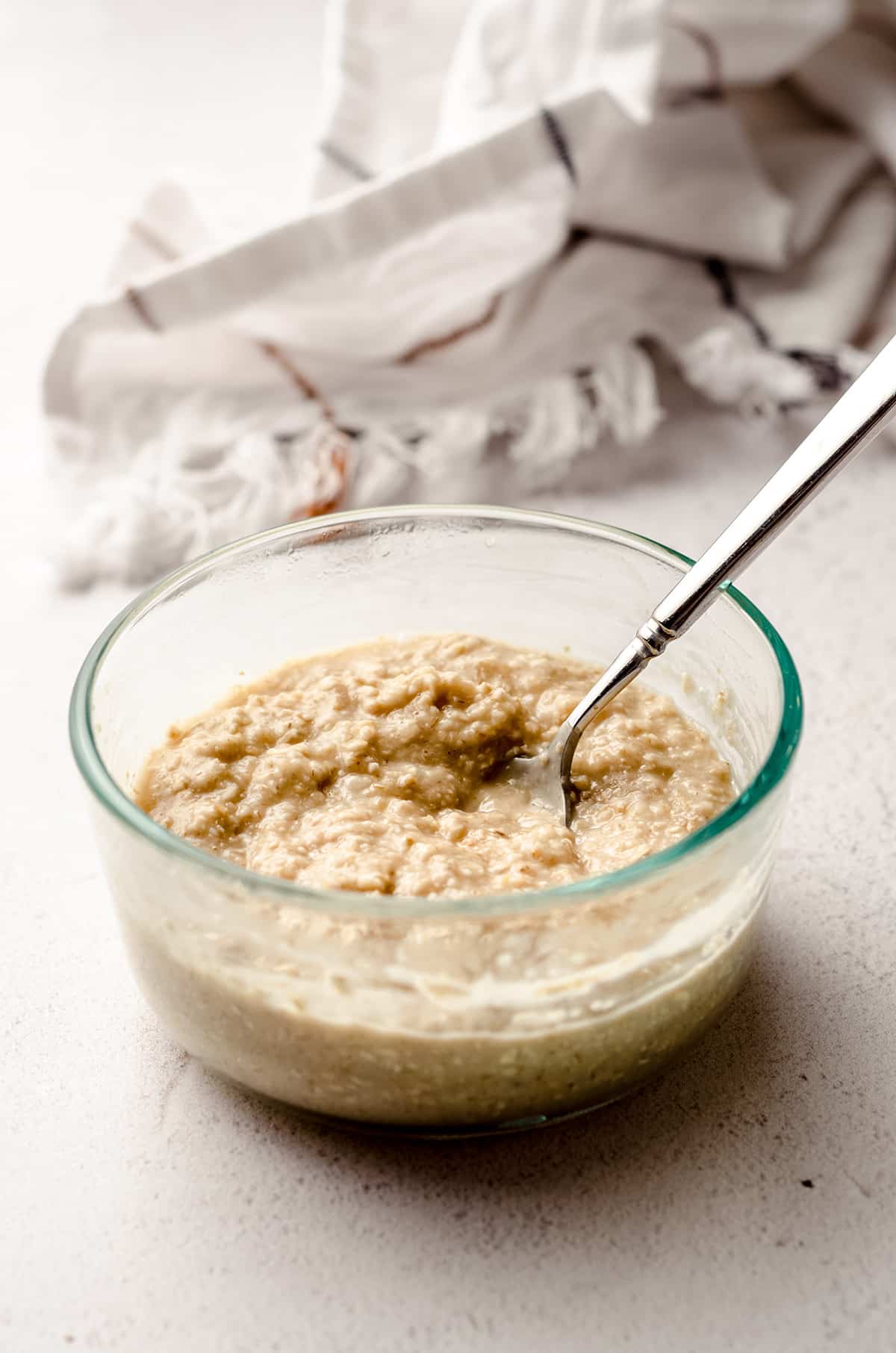 A bowl of prepared oatmeal with a spoon in the bowl.