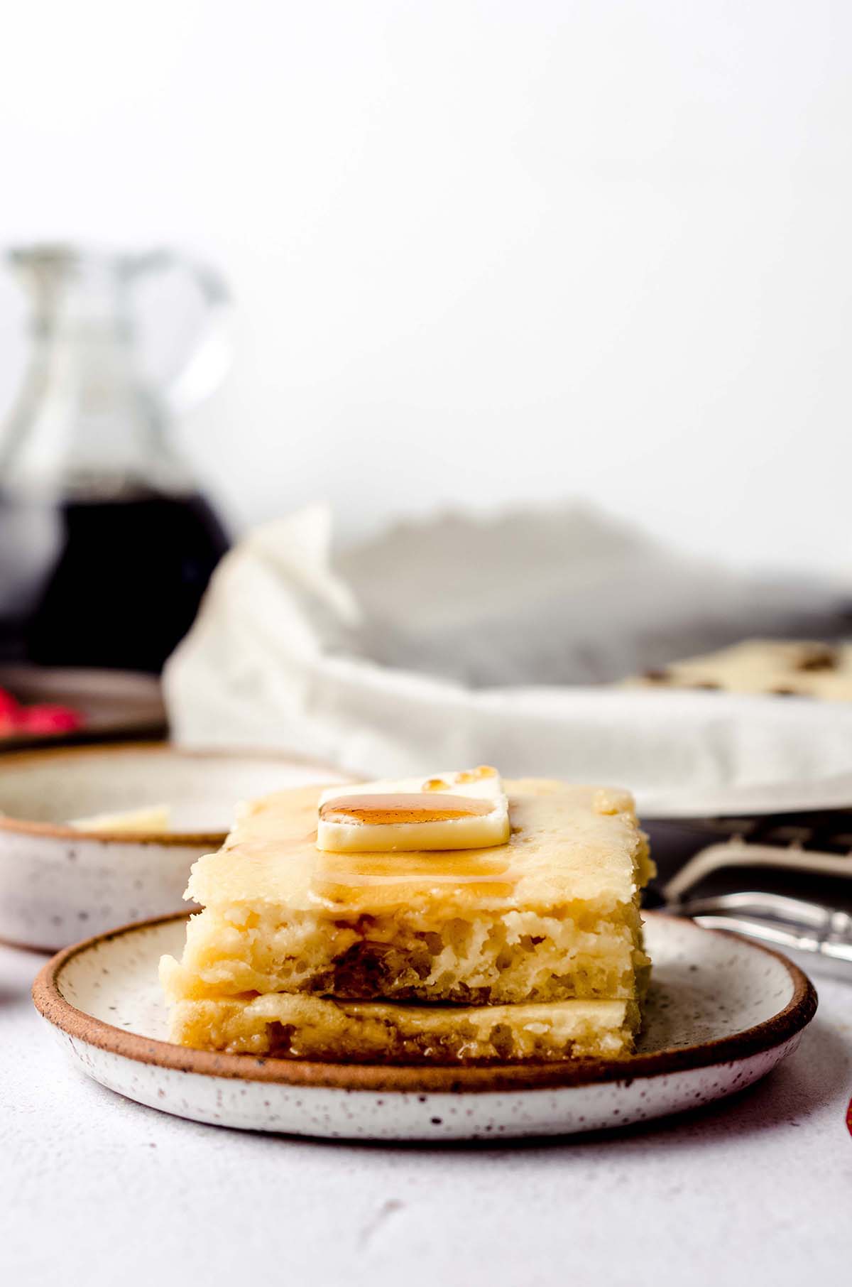 stack of sheet pan pancakes with a pat of butter and syrup