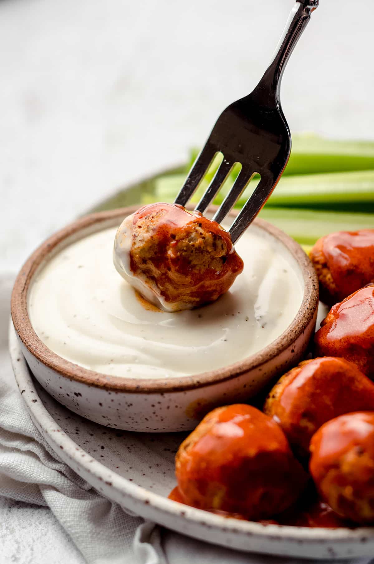 Dipping a meatball in a creamy dressing.