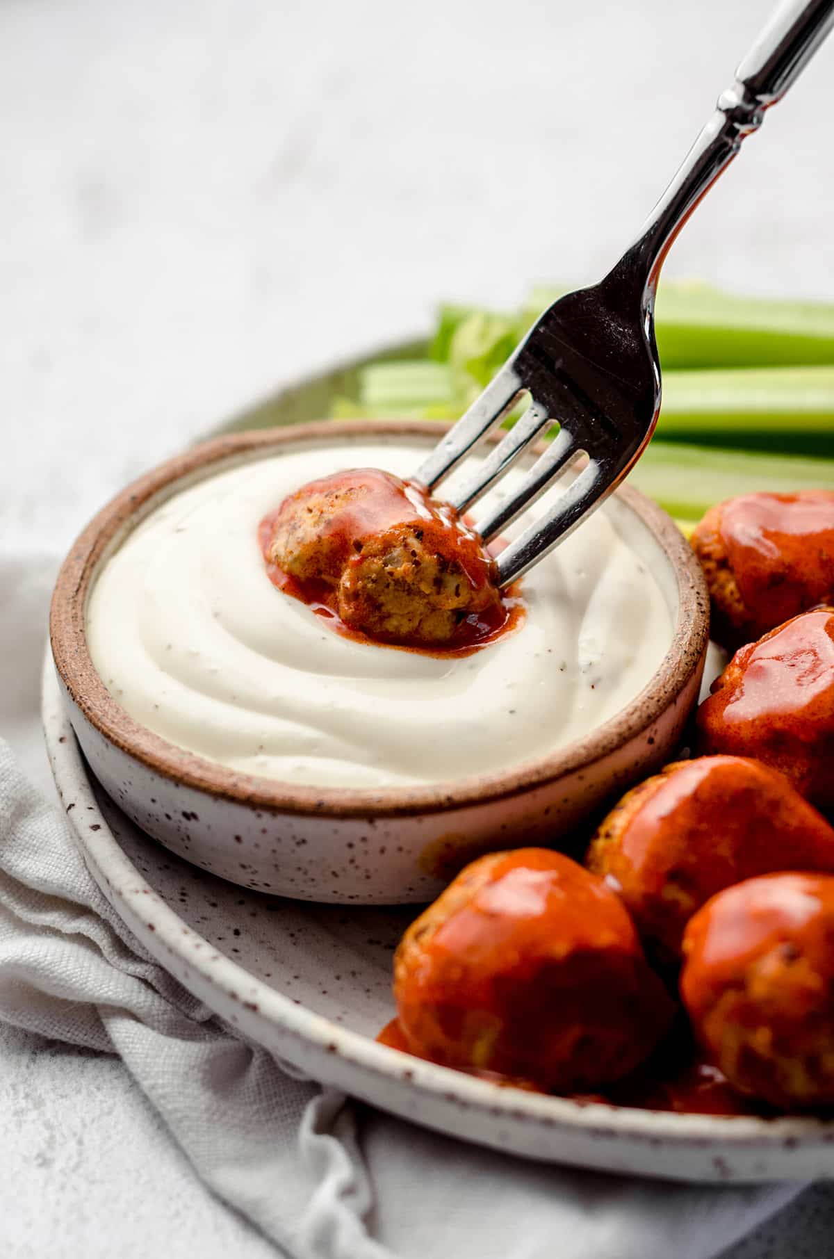 Dipping a meatball into a creamy sauce.