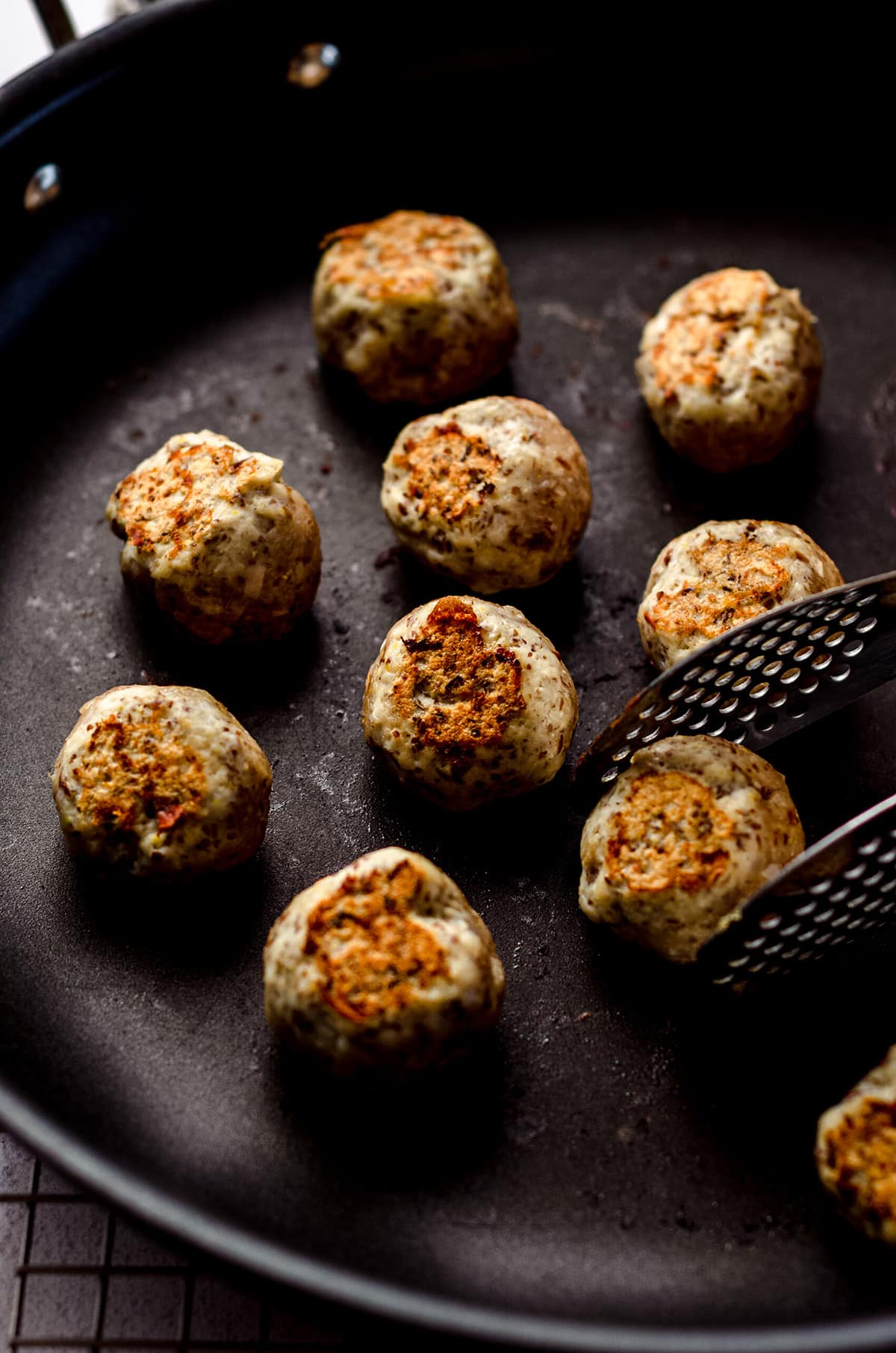 Browning meatballs in a cast iron skillet.