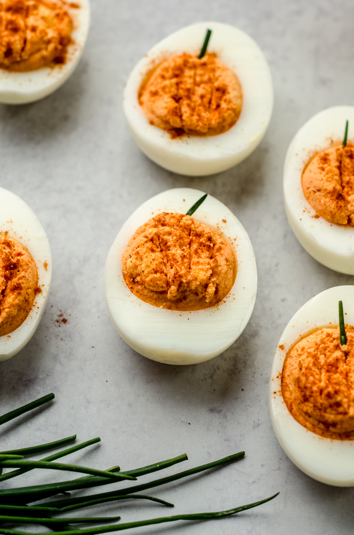 Halloween pumpkin deviled eggs on a surface.