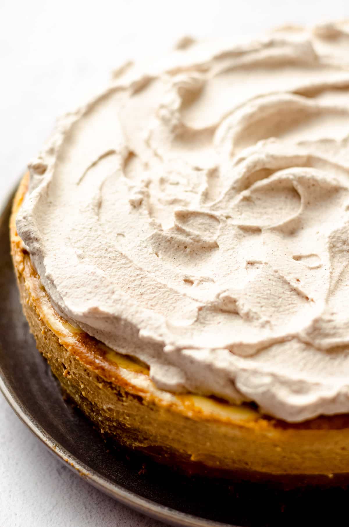 A baked cheesecake with a whipped cream topping.