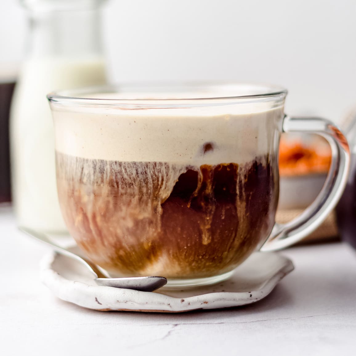 cup of pumpkin cream cold foam coffee on a plate with a spoon