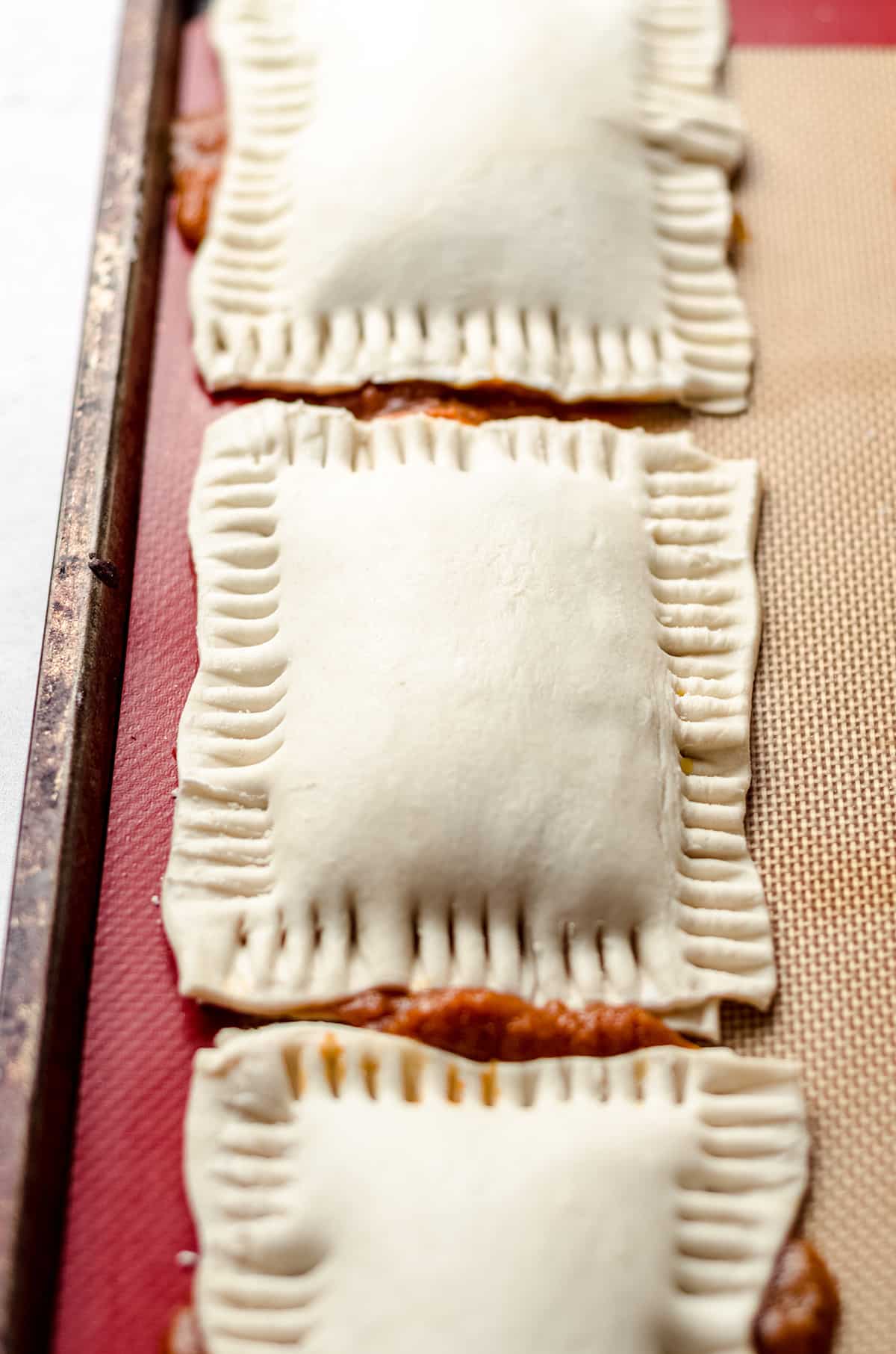 An unbaked hand pie with pinched edges.