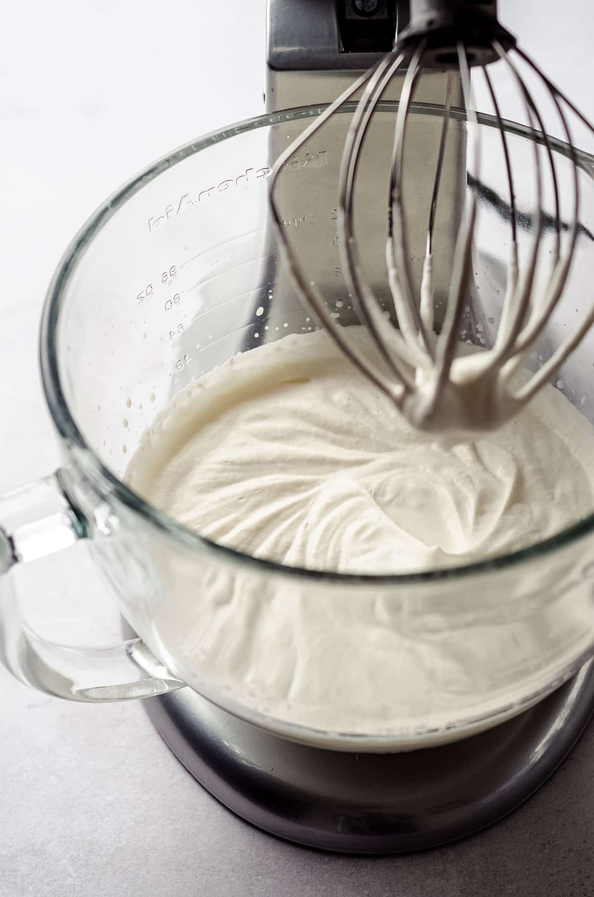 process photo of making pumpkin spiced whipped cream while it is in the bowl of a stand mixer