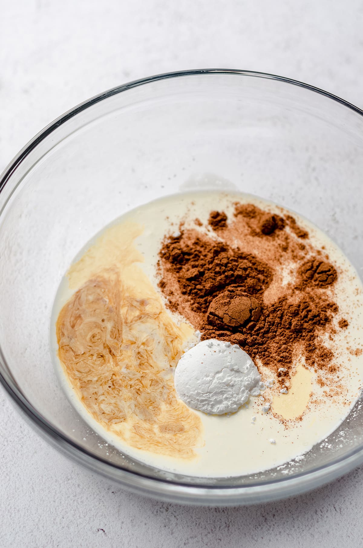 ingredients for pumpkin spice whipped cream in a glass bowl
