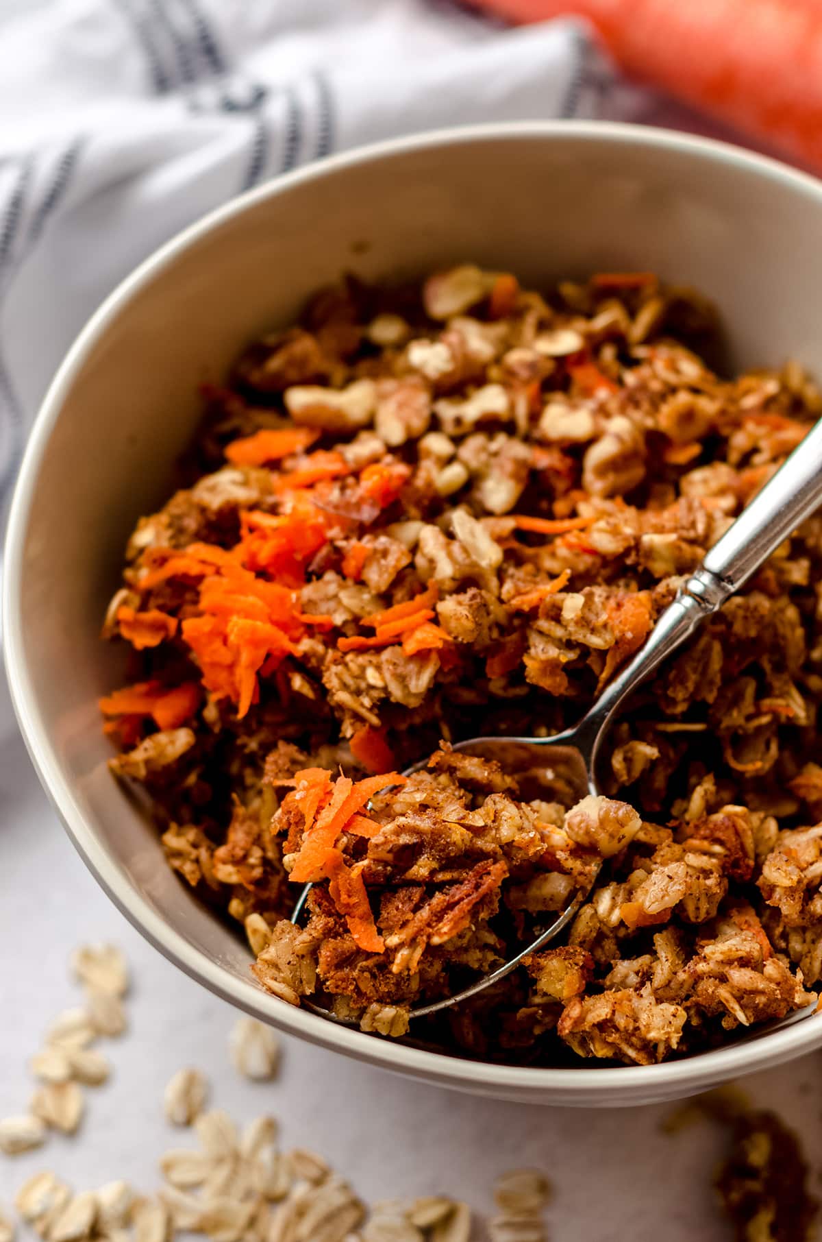 carrot cake baked oatmeal in a bowl with a spoon