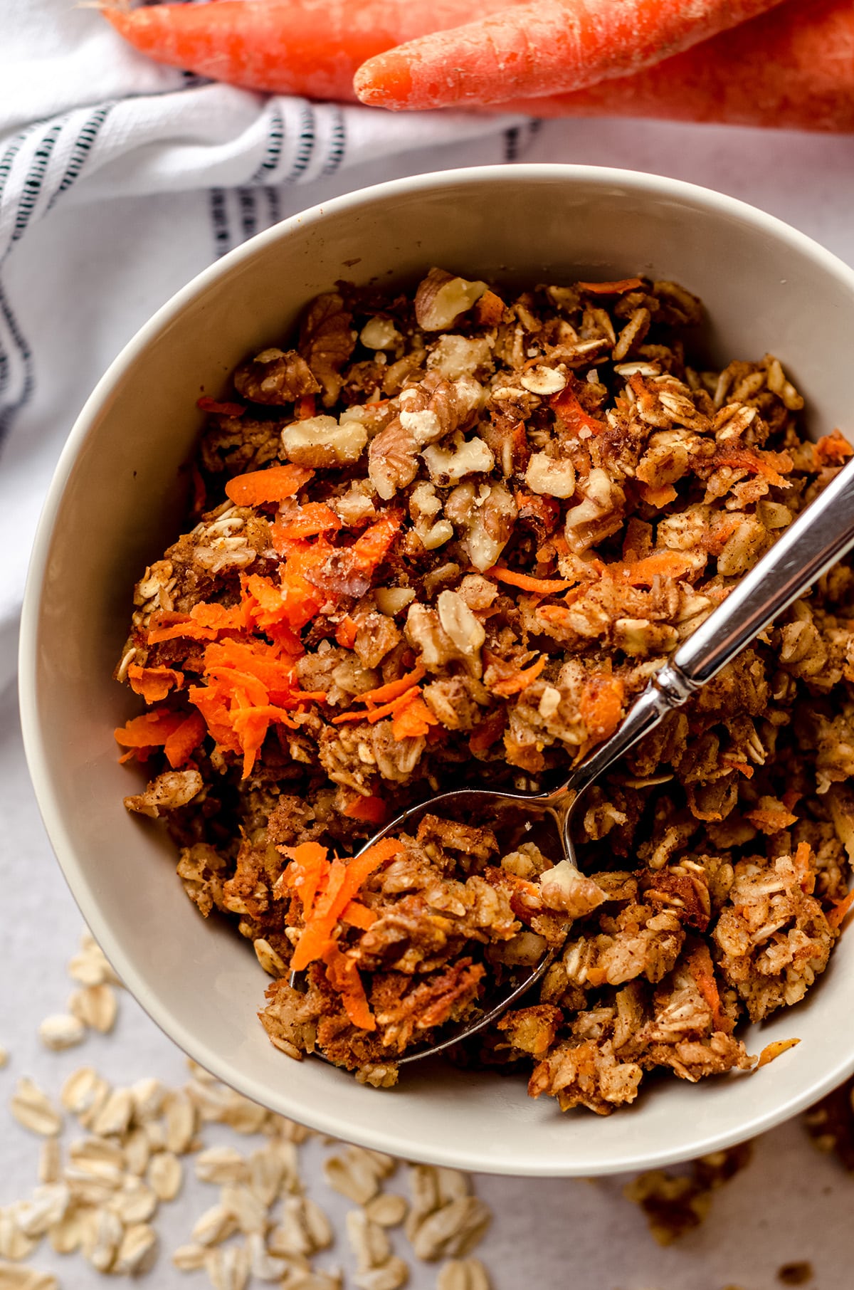 carrot cake baked oatmeal in a bowl with a spoon