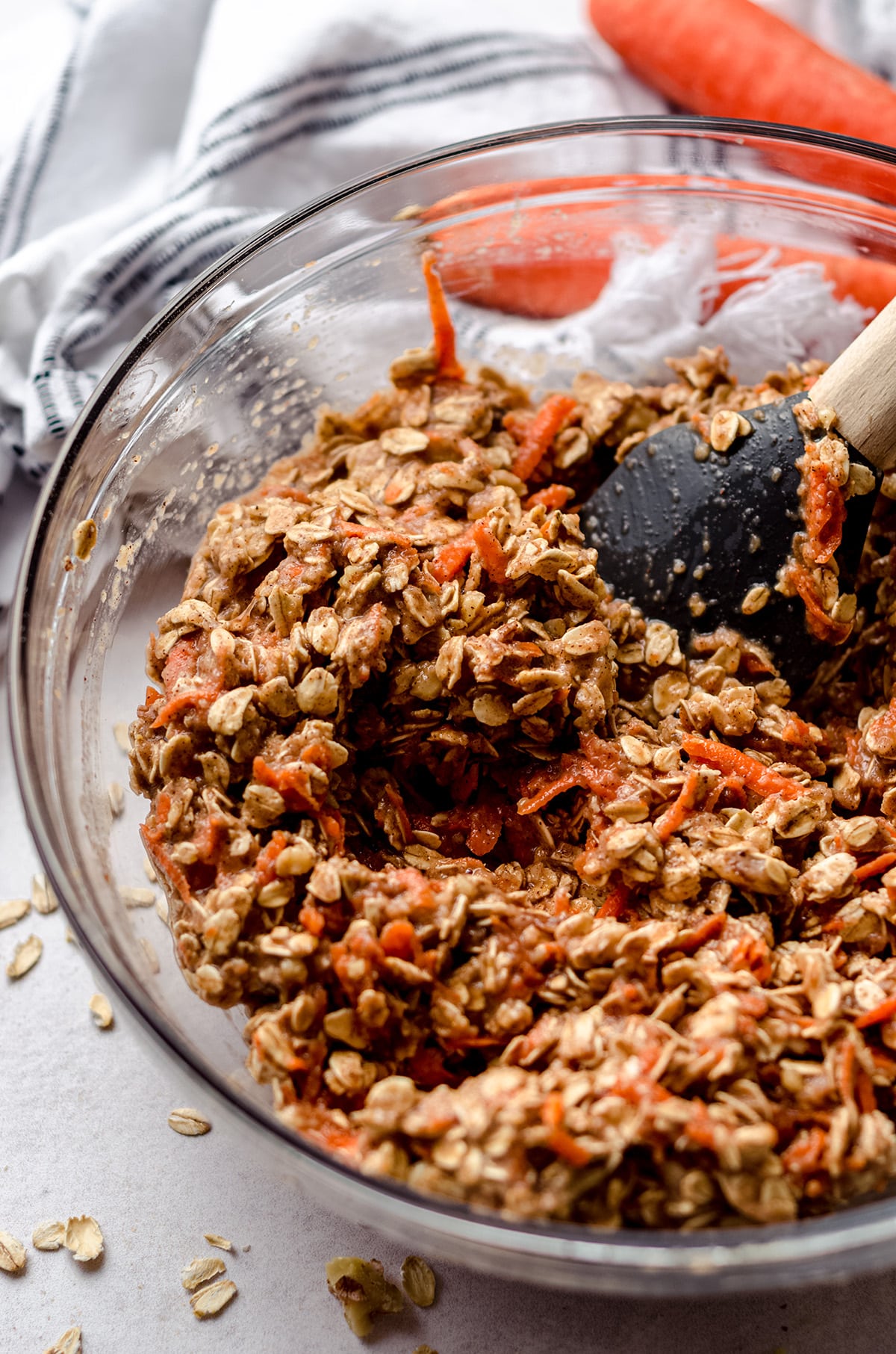 mixture for carrot cake baked oatmeal in a glass bowl with a spatula