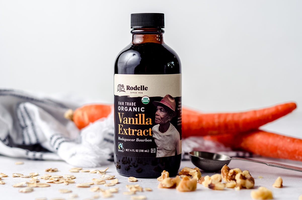 bottle of rodelle fair trade vanilla extract with carrots, walnuts, and oats around it