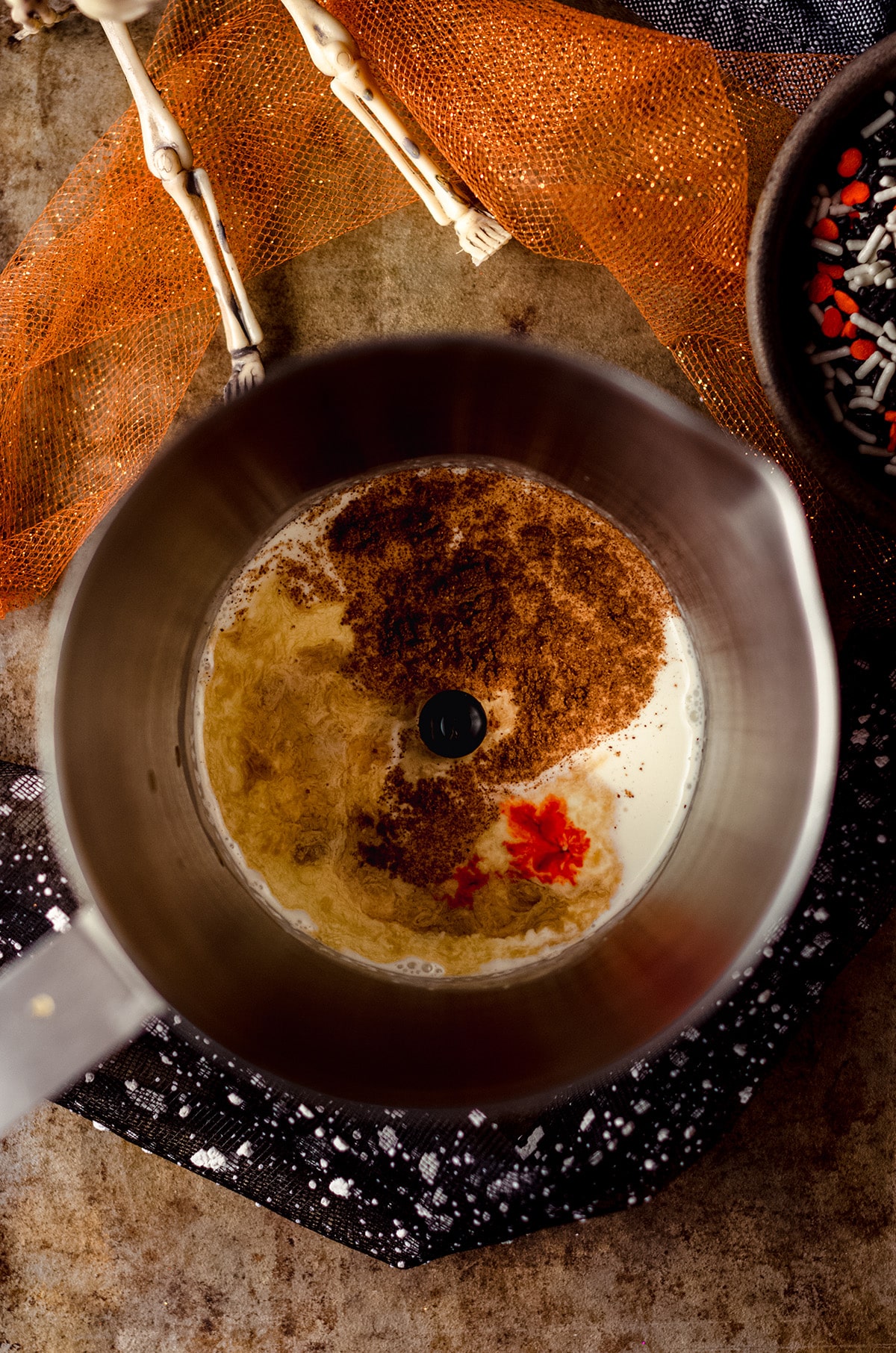 aerial photo of milk frother with pumpkin spice cold foam ingredients in it