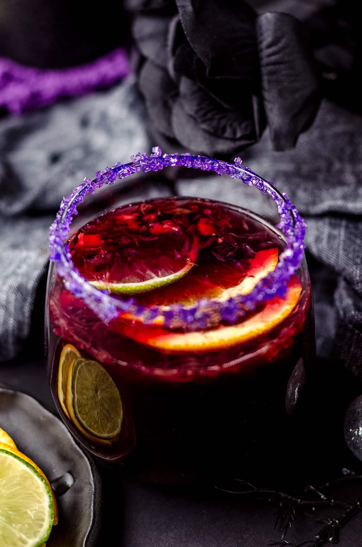 glass of halloween sangria with halloween decor around it